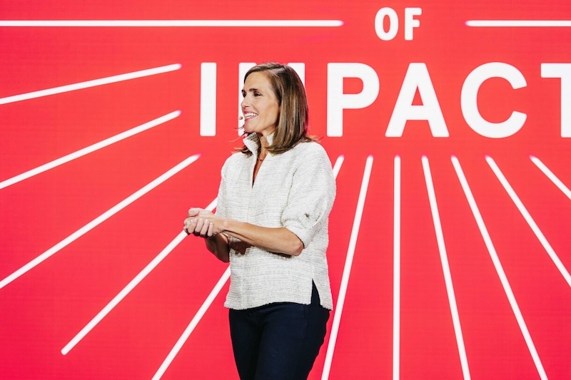 2025 Impact Accelerator Conference speaker on stage with red background and partial "IMPACT" text.