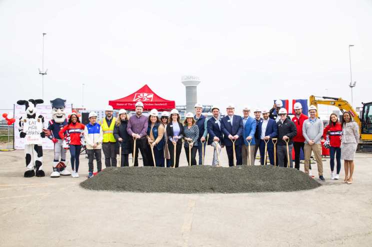 Group at a groundbreaking ceremony with shovels and a Chick-fil-A branded red tent.