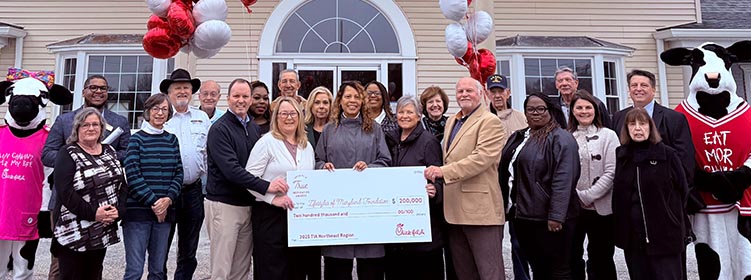 People from the LifeStyles of Maryland organization standing together smiling with two Chick-fil-A Cows and holding a large check