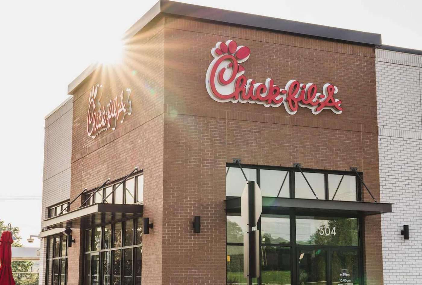 Exterior of a Chick-fil-A restaurant with sunshine and a visible logo.