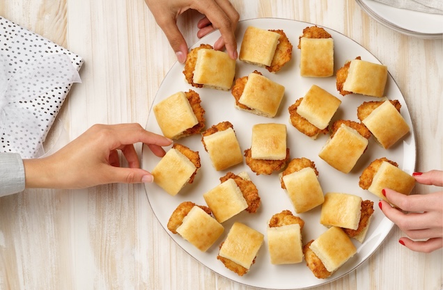 Hands reaching for mini sandwiches on a Chick-fil-A Chick-n-Minis® Tray.
