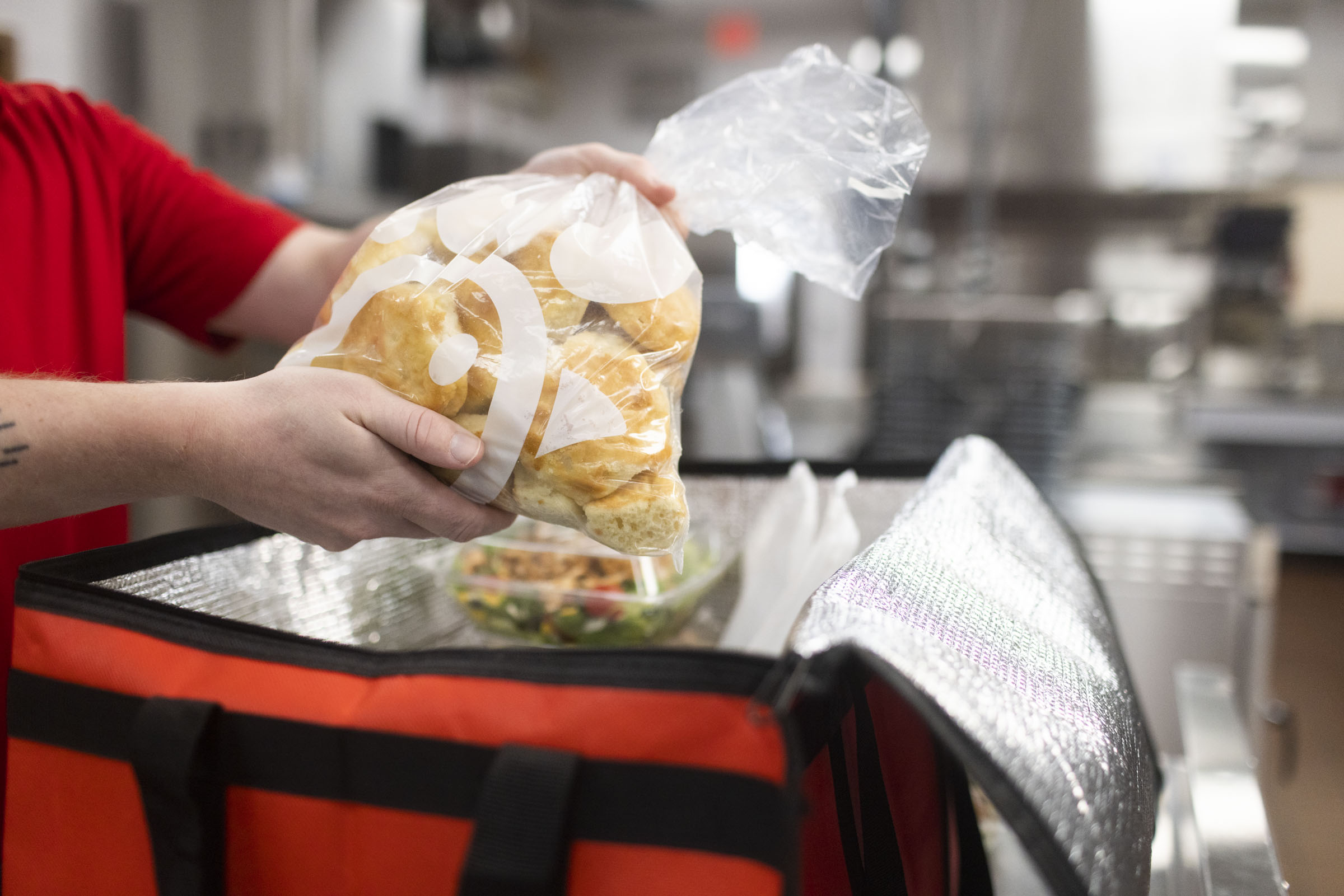 A team member packing a bag of food for donation.