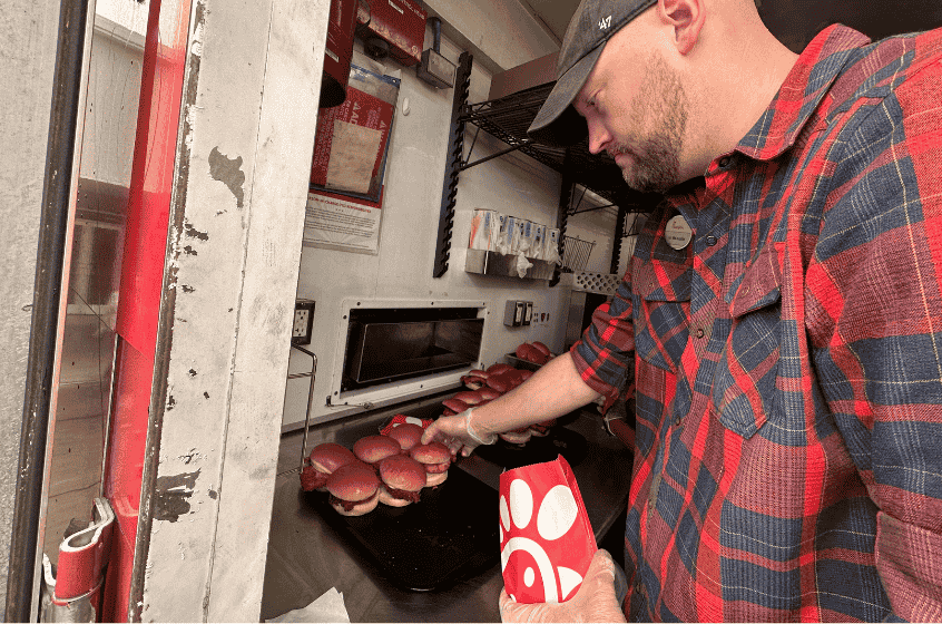 A man cooking in a Chick-fil-A Mobile Kitchen.