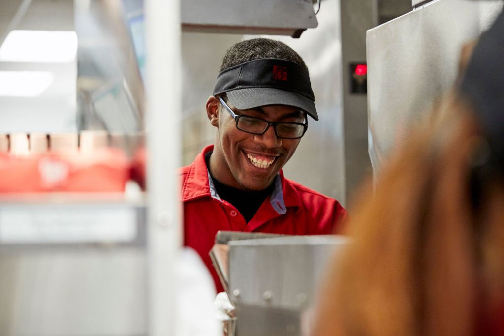 A smiling team member in a Chick-fil-A kitchen.