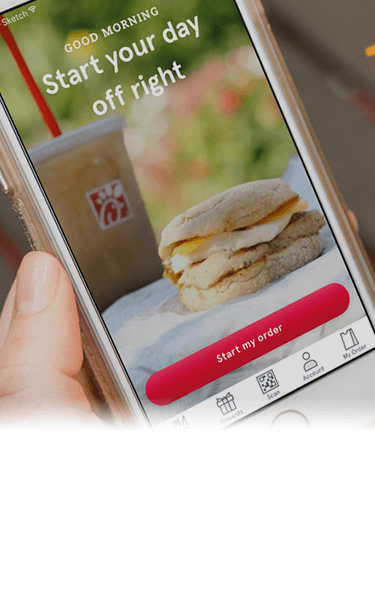 Person holding a smartphone displaying the Chick-fil-A app