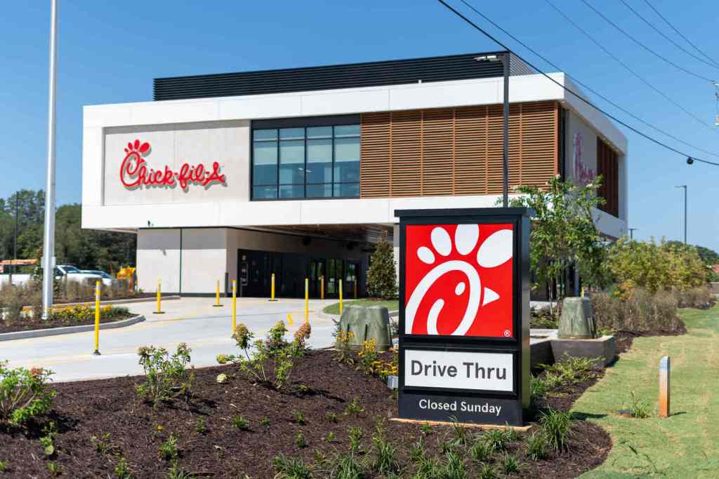Chick-fil-A restaurant exterior with drive-thru entrance and sign reading “Closed Sunday.”