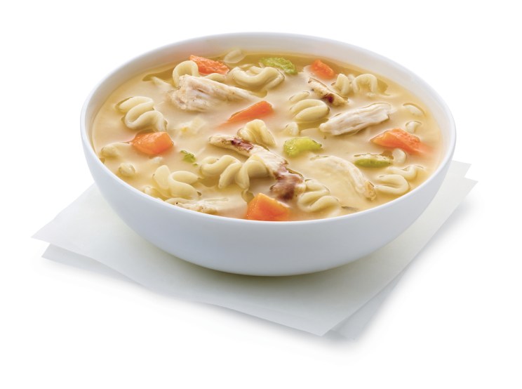 Chicken noodle soup served in a white bowl.