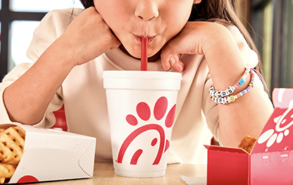A girl sipping a beverage inside a Chick-fil-A Restaurant 