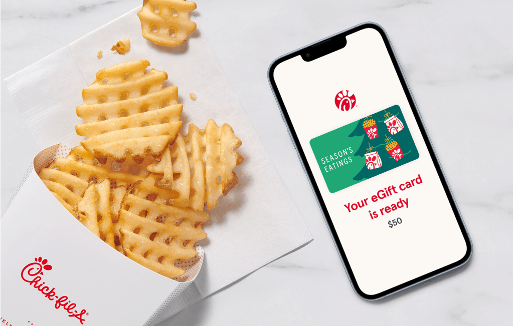 A smartphone with a Chick-fil-A® eGift card on the screen that says "Season's Greetings," sitting next to Waffle Fries
