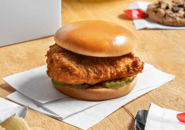 A Chick-fil-A® Chicken Sandwich on a white napkin on a wooden table