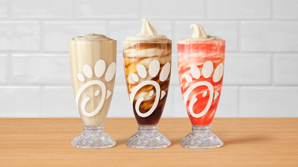 Chick-fil-A's Frosted Soda's and Floats in a row of 3 glasses sitting on a table.
