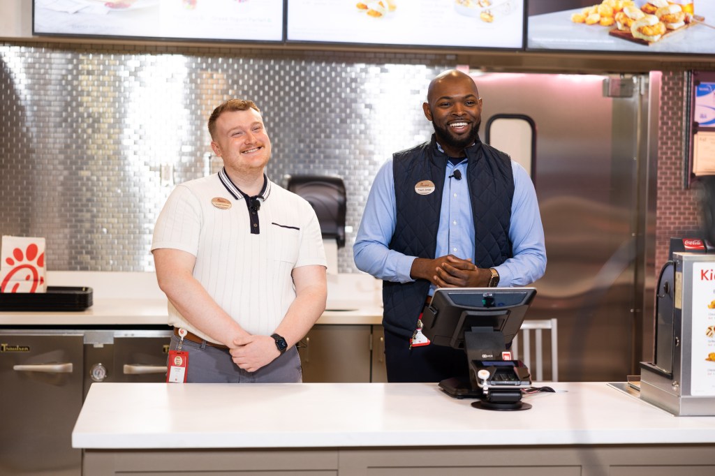 Two smiling Team Members standing behind the counter at a Chick-fil-A Restaurant