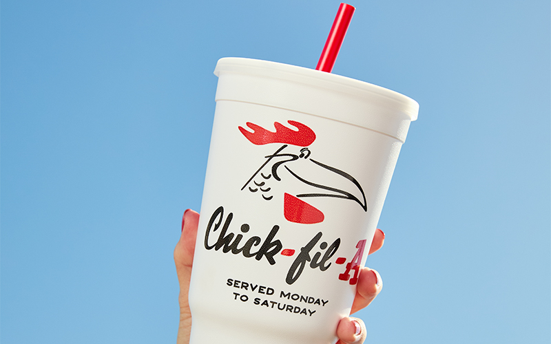 Person holding the Doodles Classic Cup with the sky in the background