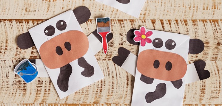 Two Cow Puppet crafts laying on a table