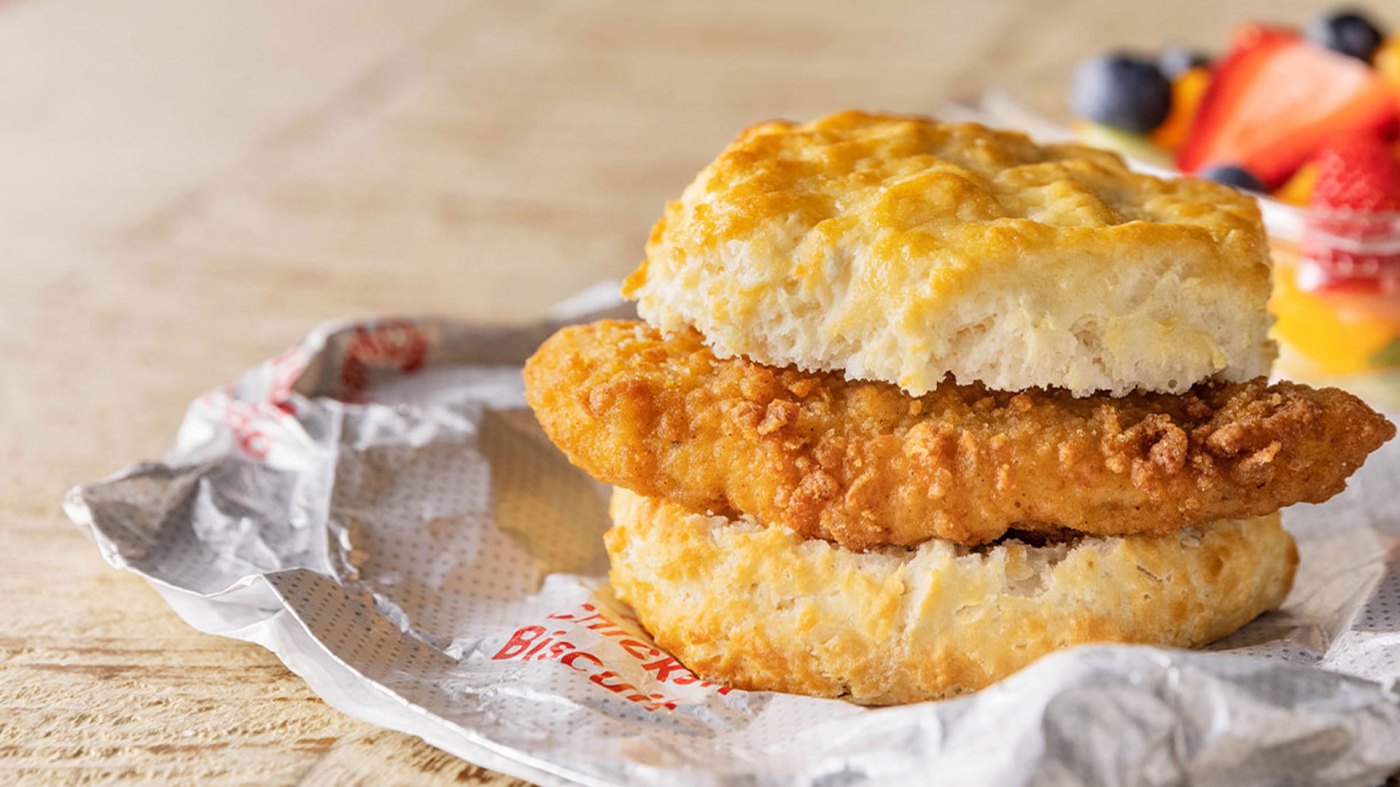 A Chick-fil-A Chicken Biscuit sitting on a wrapper on a table.
