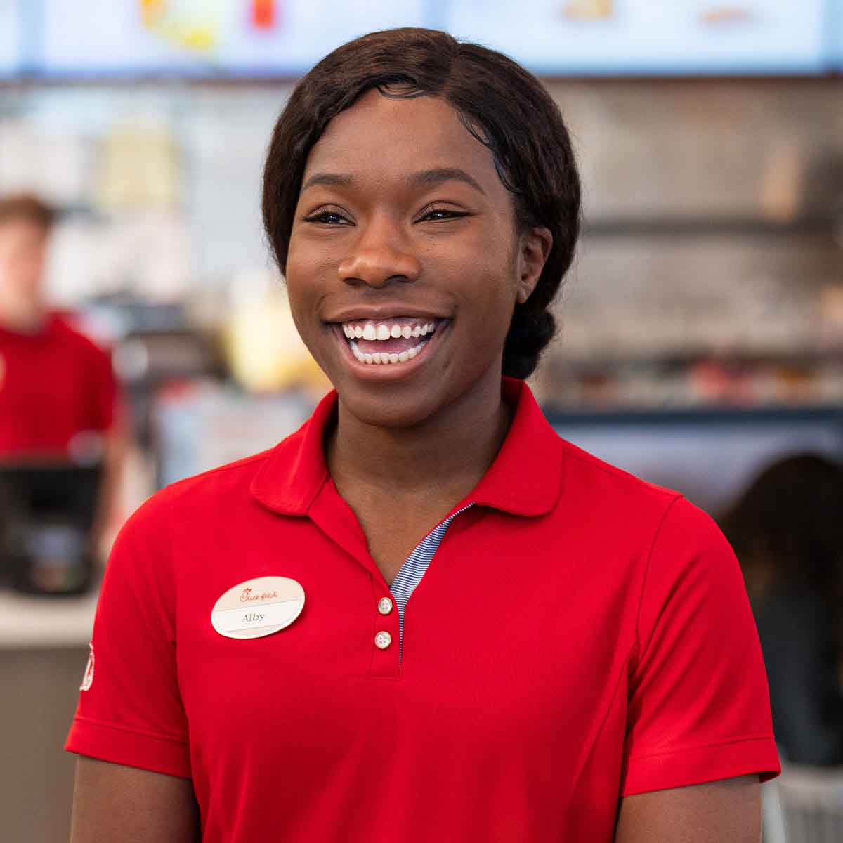A female Team Member standing at a counter and smiling