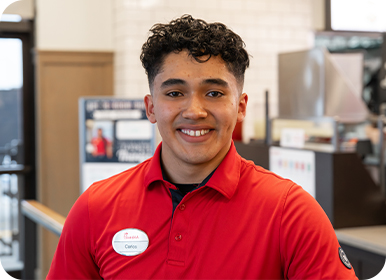 Headshot of Team Member Carlos standing in a Restaurant smiling