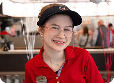 Headshot of Team Member Reagan standing in a Restaurant smiling