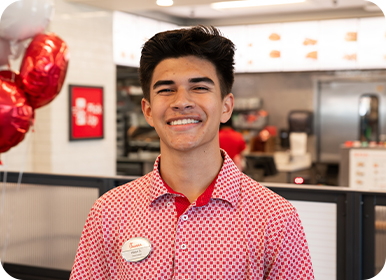 Headshot of Team Member Aaron standing in a Restaurant smiling