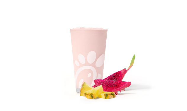 A glass of Pineapple Dragonfruit Frosted Lemonade with slices of pineapple and dragonfruit