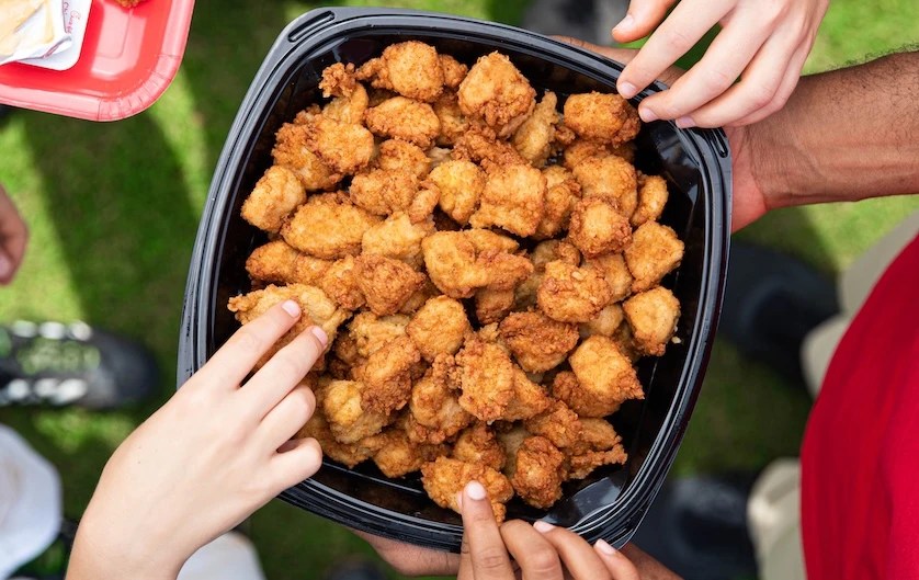 People standing outside around a Chick-fil-A® Nuggets Tray