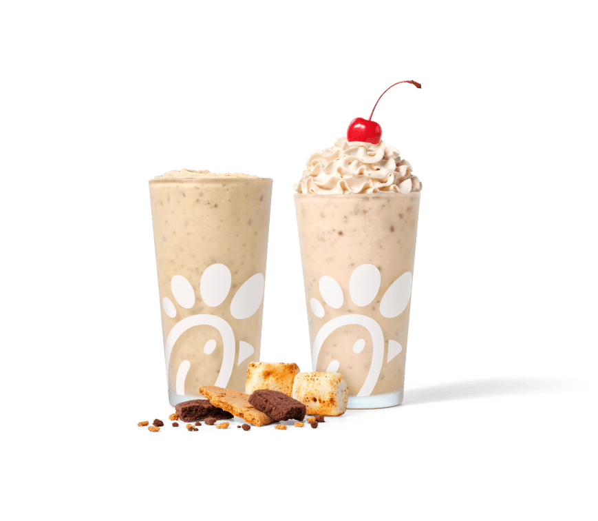 S’mores Frosted Coffee and S’mores Milkshake with two toasted marshmallows and chocolate shortbread & graham cracker crumbles on a brown checkered tablecloth