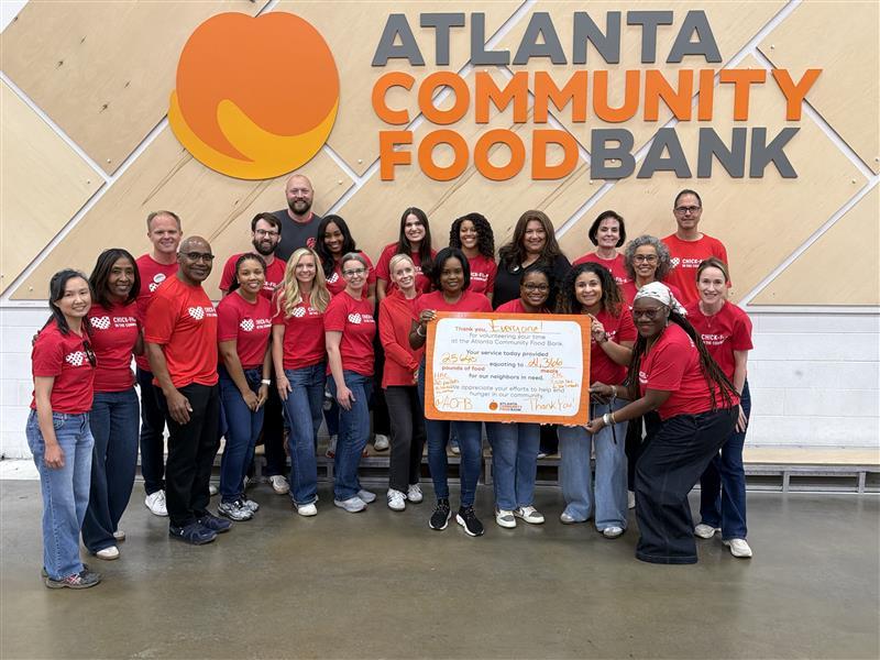 Chick-fil-A volunteers prepare sandwiches together during a community service event.