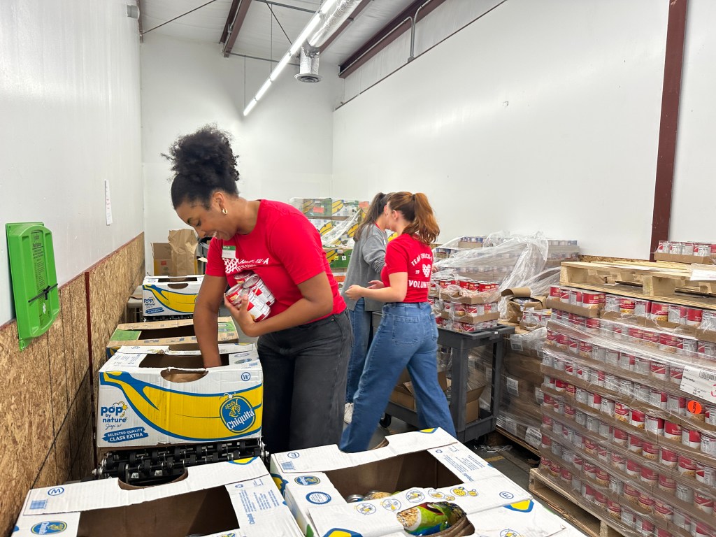 Chick-fil-A volunteers sort and pack canned food at a food bank.